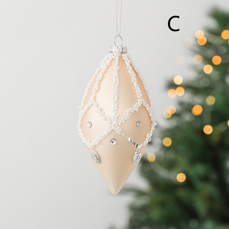 round christmas glass ornament peach colour with white decoration in a shape of drop