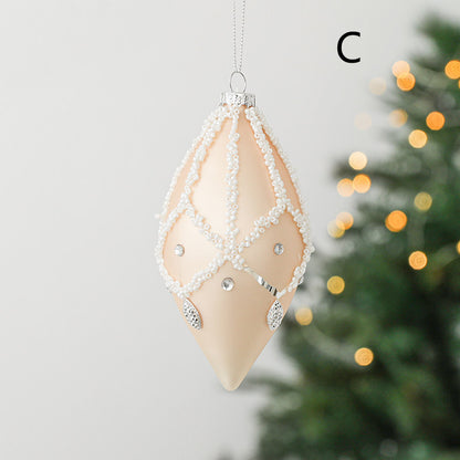 round christmas glass ornament peach colour with white decoration in a shape of drop